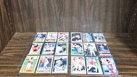 First image showing a display of 18 baseball cards arranged on a wood surface, featuring Cal Ripken Jr in various action poses.