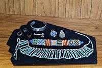 Full layout of all jewelry pieces on black display including choker, bracelet, cuff, rings, and pendants.