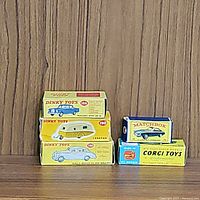 Group shot showing all five boxed vehicles and caravan lined up on wood background