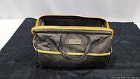 Gray nylon tool bag with yellow accents shown empty, front view