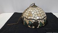 Full view of the Tiffany style stained glass hanging light dome with metal chain and canopy.