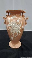 Front view of the Weller Pottery vase showing floral relief detail and decorative handles.