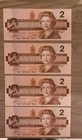 Front side of the four consecutive 1986 Canadian $2 banknotes featuring Queen Elizabeth II in uncirculated condition.