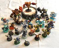Full view of 24 Skylanders figures arranged around the circular Portal of Power base, showing variety of characters and colors.