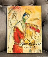 Front cover of hardcover book showing a colorful artistic depiction of a crowned figure playing a harp with a woman behind him.