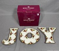 Set of three Royal Albert ceramic candy dishes spelling 'JOY', with Royal Albert original box behind