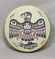Front view of vintage Haida style hand drum showing eagle and fish artwork and signature on drum surface.