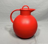 Full frontal view of the red spherical Alfi carafe thermos sitting upright, showing handle and spout.