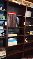 Front view of the dark brown IKEA Billy bookcase with various books and small decorative items on shelves.