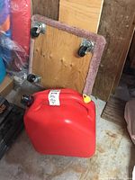 Wooden dolly partially covered in purple carpet showing its four caster wheels