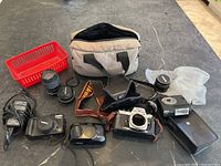Overview of all items: Nikon FE2 body, lenses, flash, digital cameras, charger and bag