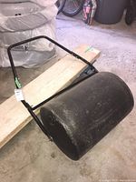 Black lawn roller viewed from above showing handle attached and overall size.