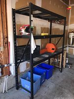 Front view of black steel shelving unit showing three visible wire mesh shelves and overall structure