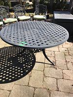 Front-right view of round lattice top and part of base on stone patio