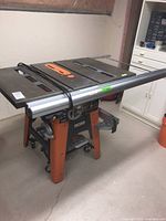 Front and angled view of table saw on stand with fence rail attached