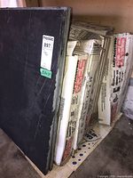 Stack of 3 large stone tiles with partial view of boxes behind