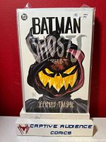 Front cover of Batman Ghosts #1 comic showing a dark hooded figure with glowing pumpkin face and title text on white background.