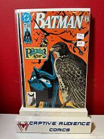 Front cover of Batman #449 comic book displayed upright in protective plastic sleeve against a red background, includes two price stickers and Captive Audience Comics stand.