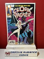 Front cover of Cloak and Dagger #1 comic book in protective sleeve, showing cover art and condition, resting on white stand with Captive Audience Comics logo
