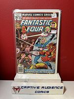 Photo of Fantastic Four #195 comic book standing upright against a red background, inside a protective sleeve with price stickers.