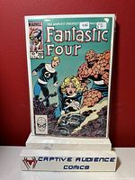 Photo of Fantastic Four #260 comic book in protective plastic sleeve against a red wall, showing cover art and condition.