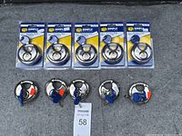 Photo of 10 stainless steel disc locks, 5 in original packaging and 5 outside packaging with blue keys inserted, displayed on a surface
