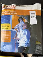 Photo of product packaging showing man and child using the escape ladder with product details and branding visible.