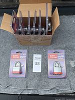 Box open showing eight new Public Storage padlocks in original packaging.