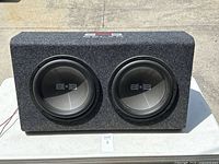 Front and side view of dual subwoofer speaker box with two 12-inch Belva subwoofers mounted in carpeted enclosure.