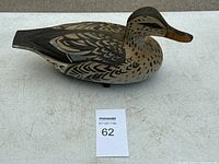 View of the left side of the wooden duck decoy showing detailed feather painting and profile.