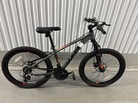 Side profile of the Huffy boys' mountain bike showing 21-speed gear system, front suspension, and large knobby tires for off-road use.