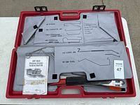 Top view of red plastic case containing the lock out tools. Tools are set in labeled molded slots. Included is an instructional pamphlet.