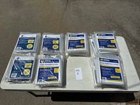 Mattress covers organized in packages by size on a table, displaying Twin, Full, Queen, and King sizes