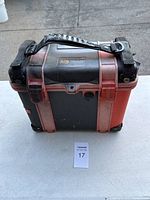 Closed Pelican 1430 case showing black and red exterior, handle, and label on top.