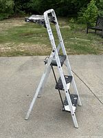 Profile side view of the metal platform ladder showing steps and paint marks