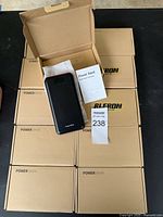 Ten boxed RLeron power banks shown with one opened displaying the device and instruction manual.