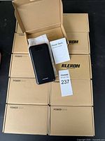 Ten boxed power banks labeled 'Power Bank' with one out of the box showing device and instruction manual.