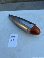 Full view of the vintage Guide M-B5 tail light showing bullet-shaped metal body with orange lens.