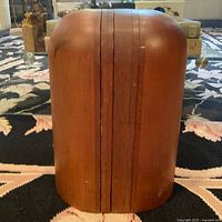 Frontal view of joined wooden slab hat stand showing smooth curved surface and wood grain patina.