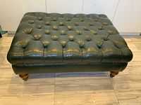 Front view of full ottoman showing tufted top and legs