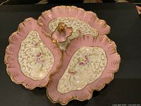 Top view of large vintage French porcelain server showing detailed floral and gold scroll pattern, pink scalloped edges, and central flower handle.
