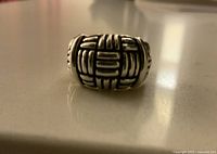 Front view of chunky silver ring showing detailed basket weave pattern and oxidized accents.