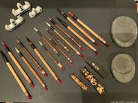 Top view of the full calligraphy set arranged on a black background showing all brushes, brush rests, ink sticks with holders, and ink stones.