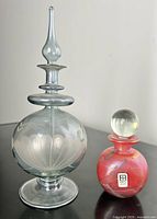 Both perfume bottles together showing size and style contrast