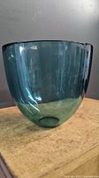 Side profile of aqua blue glass bowl showing smooth finish and curved shape
