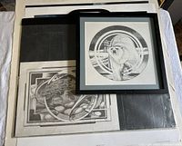 Four limited edition signed art prints arranged showing polar bear print framed on top, dragon grayscale print below, and two color northern themed prints by Chas Comfort.