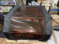 Amber tinted protective cover laid over machine bed on workbench