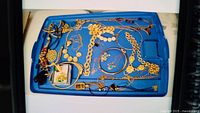 Blue tray with assorted necklaces and brooches