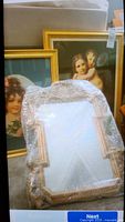 Framed prints of children and ornate mirror wrapped in bubble wrap