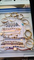 Full assortment of gold-tone, silver-tone bangles and chain bracelets displayed on tray
